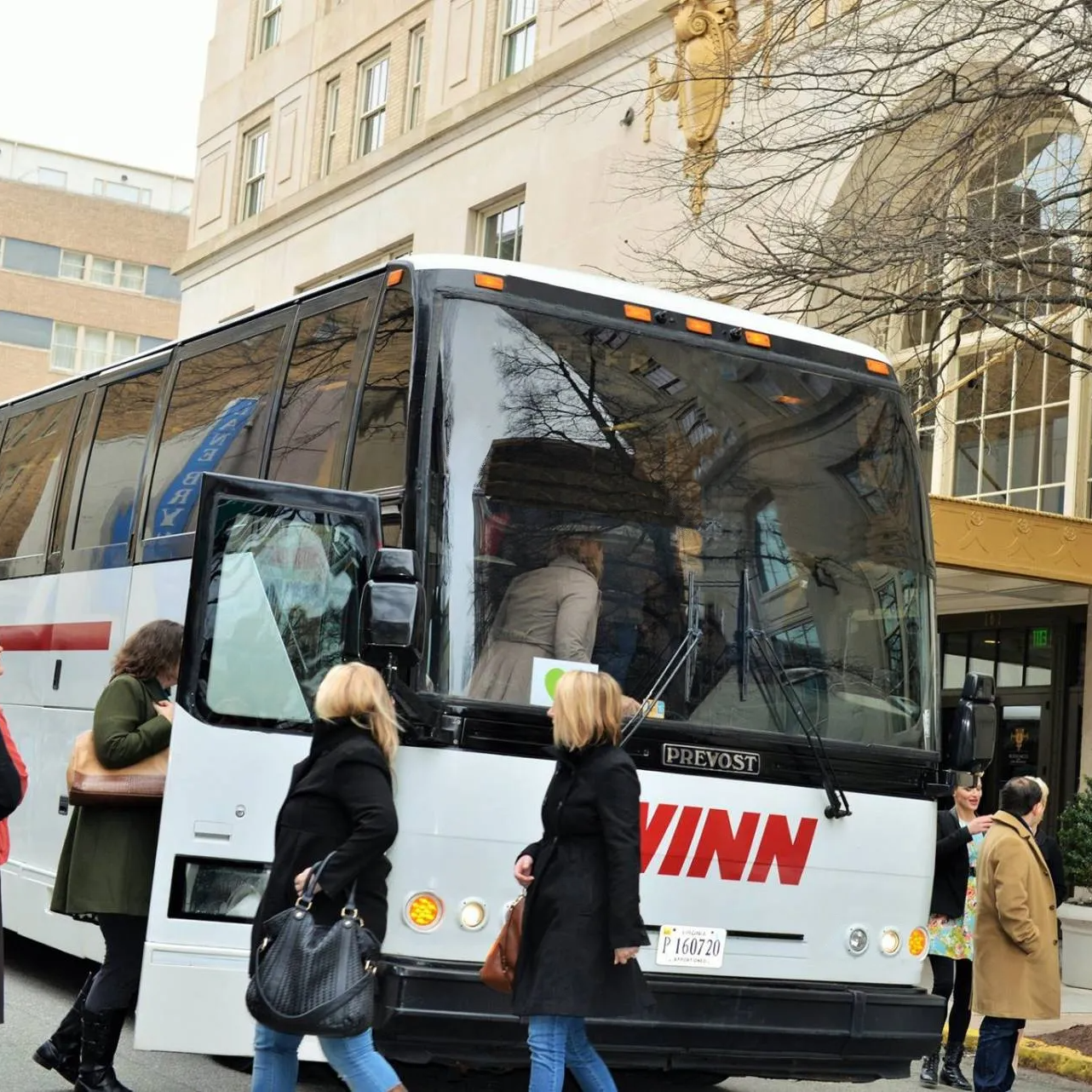 People boarding large charter bus